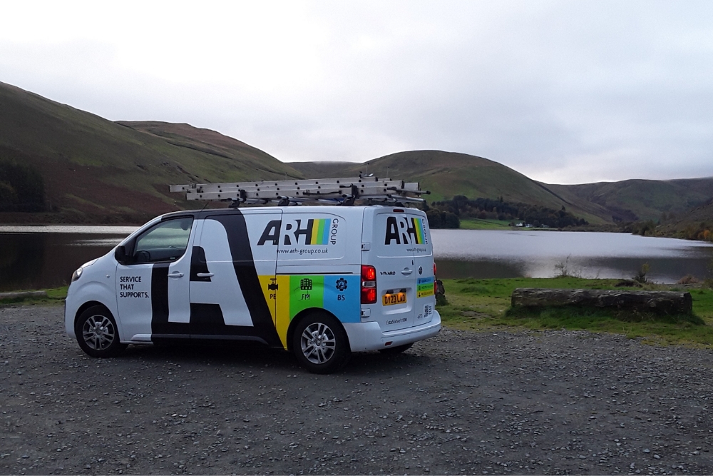ARH Group van stationed by a peaceful lakeside, blending reliable service with scenic surroundings.